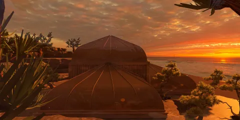 3D exterior view of a coastal dome structure at sunset, highlighting modern architectural design, emphasizing harmony with nature, featuring Homestyler's real-time 3D rendering.