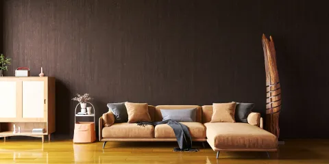 sofa with cushions in a modern living room design showcasing a rich brown wall and wooden accents, highlighting interior decor trends for Homestyler's real-time 3D rendering feature.