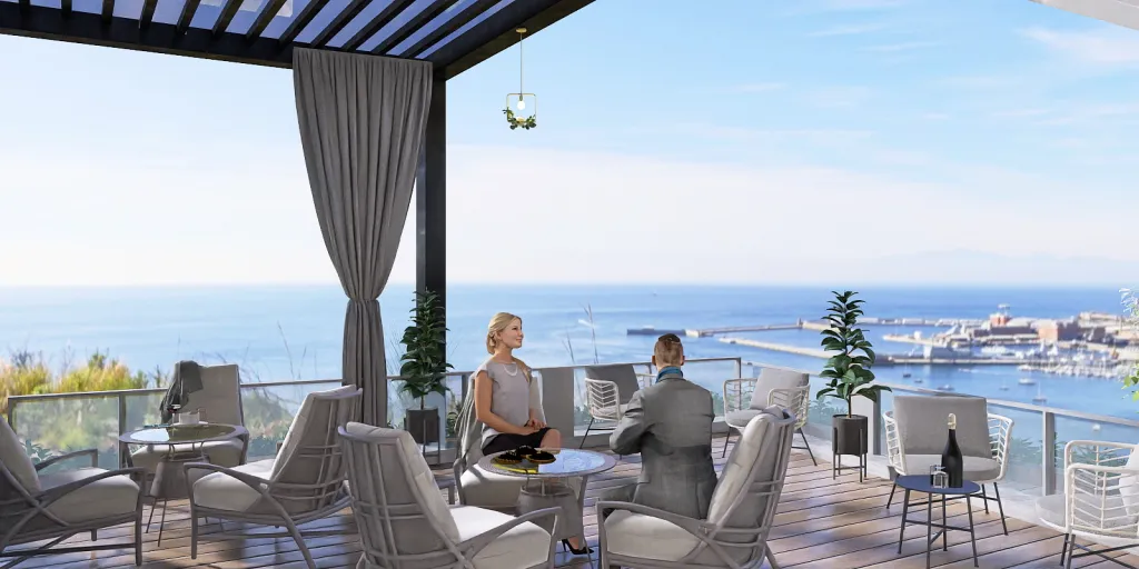 a man sitting at a table with a balcony overlooking the ocean 