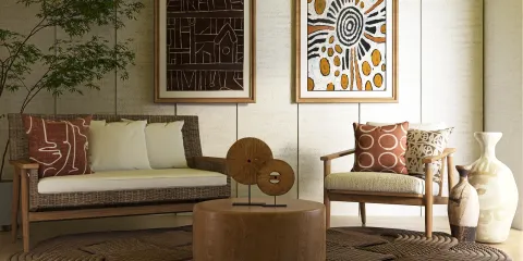 Stylish seating arrangement with decorative pillows and art pieces accenting a cozy living space in a modern bohemian style, showcasing Homestyler's real-time 3D rendering feature.